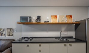 A compact kitchen with a microwave, coffee maker, and a shelf with decorative items. - Ap W/self Check-in 600m From Beach in BC Dpr0006 (Balneário Camboriú)
