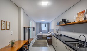A compact kitchen with a dining area, a bed, and a small window. - Ap W/self Check-in 600m From Beach in BC Dpr0006 (Balneário Camboriú)