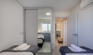 A hotel room with two beds, a sliding door, and a bathroom visible through the door. - 3BR apt w/ Gourmet Balcony & sea View - Shc0506 (Picarras)