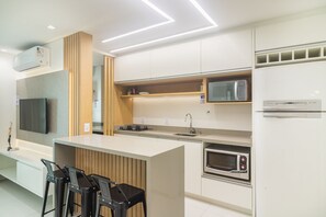 A modern kitchen with a central island, built-in microwave, and stainless steel appliances. - 3BR apt w/ Gourmet Balcony & sea View - Shc0506 (Picarras)
