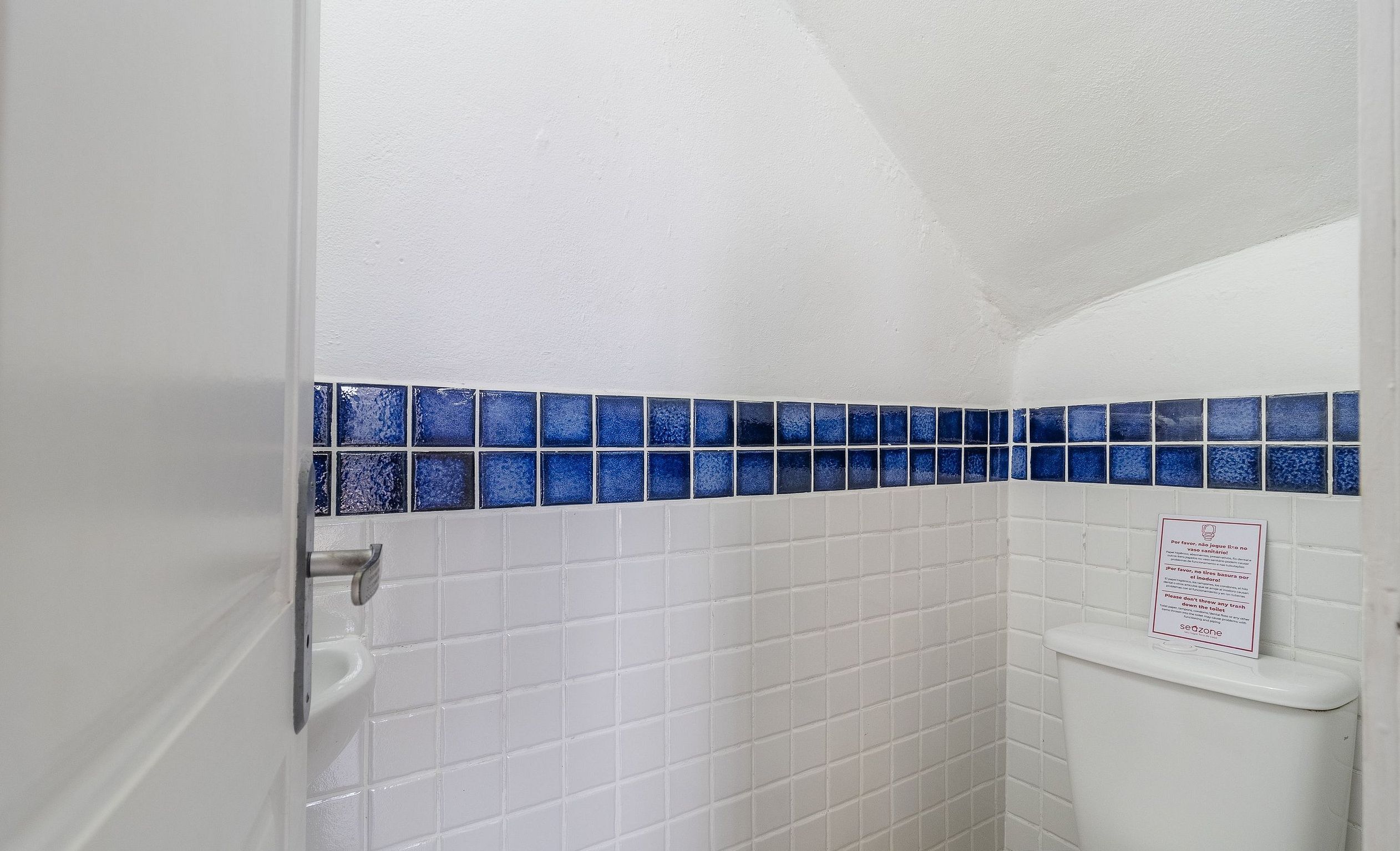 Een badkamer met witte tegels en een accentmuur in blauwe tegels.
