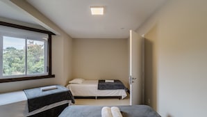 A small, single-room hotel room with a bed, a bench, and a window. - 2BR Duplex w/ Pool 350m From Sea Vle003 (Bombinhas)