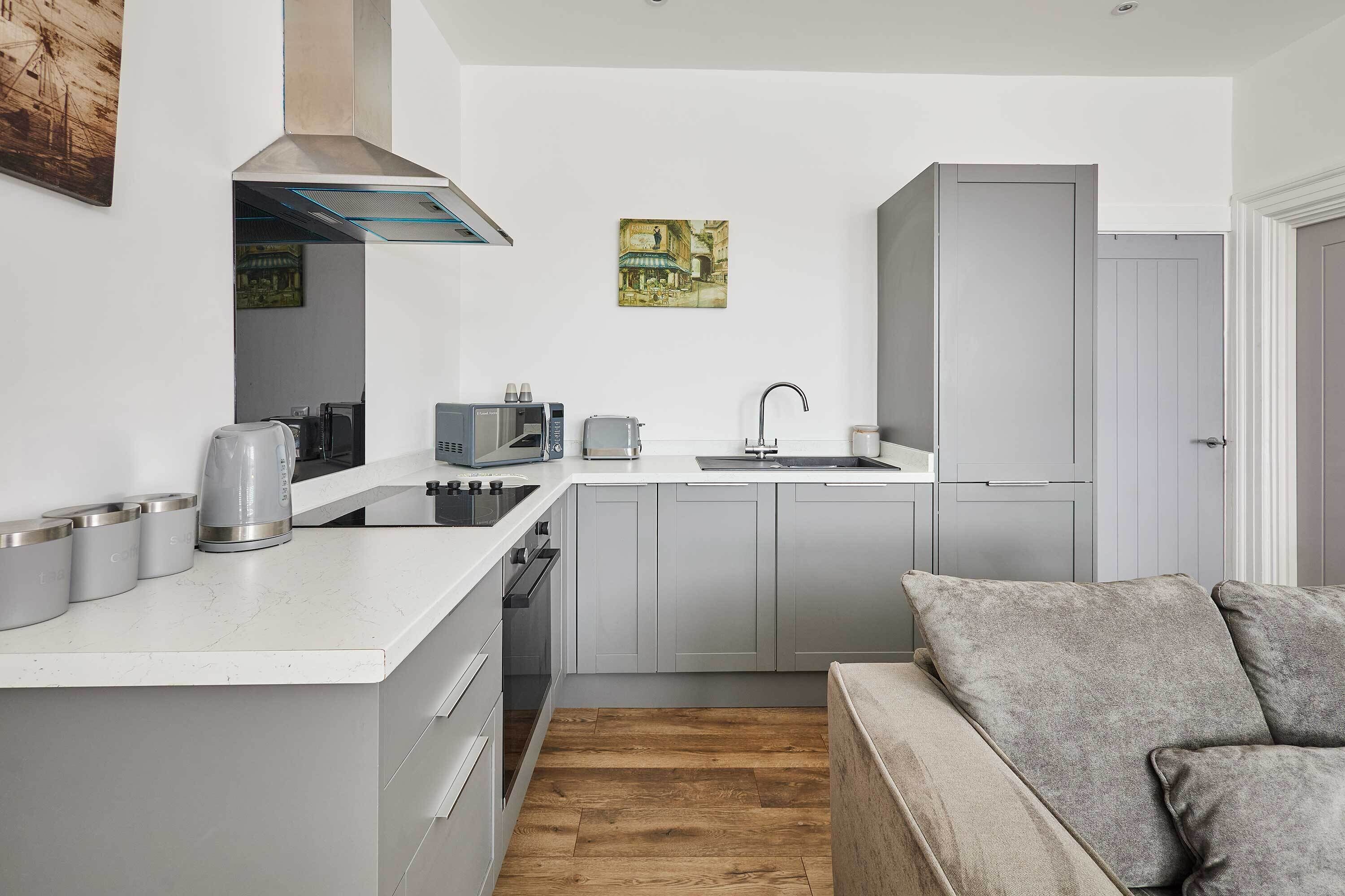 A compact kitchen with a central island, a built-in oven, and a sink.