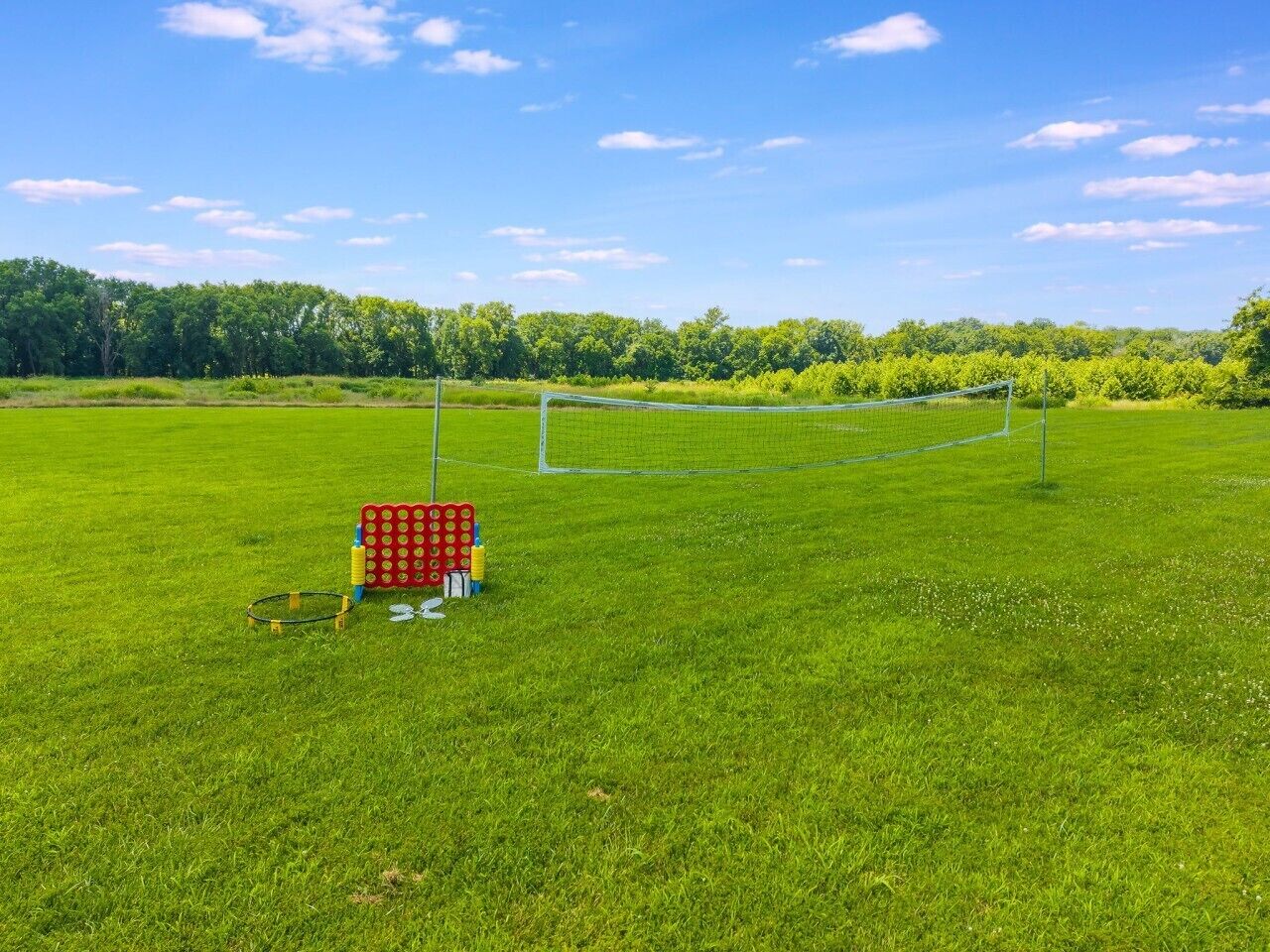 Un terrain de football avec des poteaux de but, un filet de but rouge et jaune, ainsi qu’un ensemble de ballons de football et de cônes.