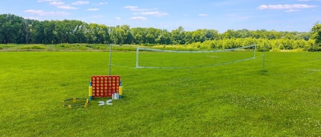 Un terrain de football avec des poteaux de but, un filet de but rouge et jaune, ainsi qu’un ensemble de ballons de football et de cônes.