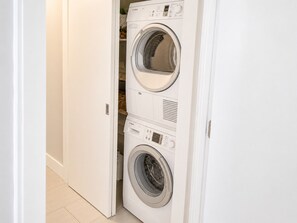 A compact, white, two-door laundry room with a built-in washer and dryer. - 2 bedroom 2 bath Luxury Beachfront condo on Longboat Key (Longboat Key)