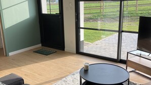 Ein modernes Wohnzimmer mit einer Couch, einem runden Couchtisch und einem Fernseher auf einem Schrank.
