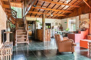 Un interior espacioso con una escalera que conduce a un nivel superior, una zona de estar con sofá y una barra con mostrador.