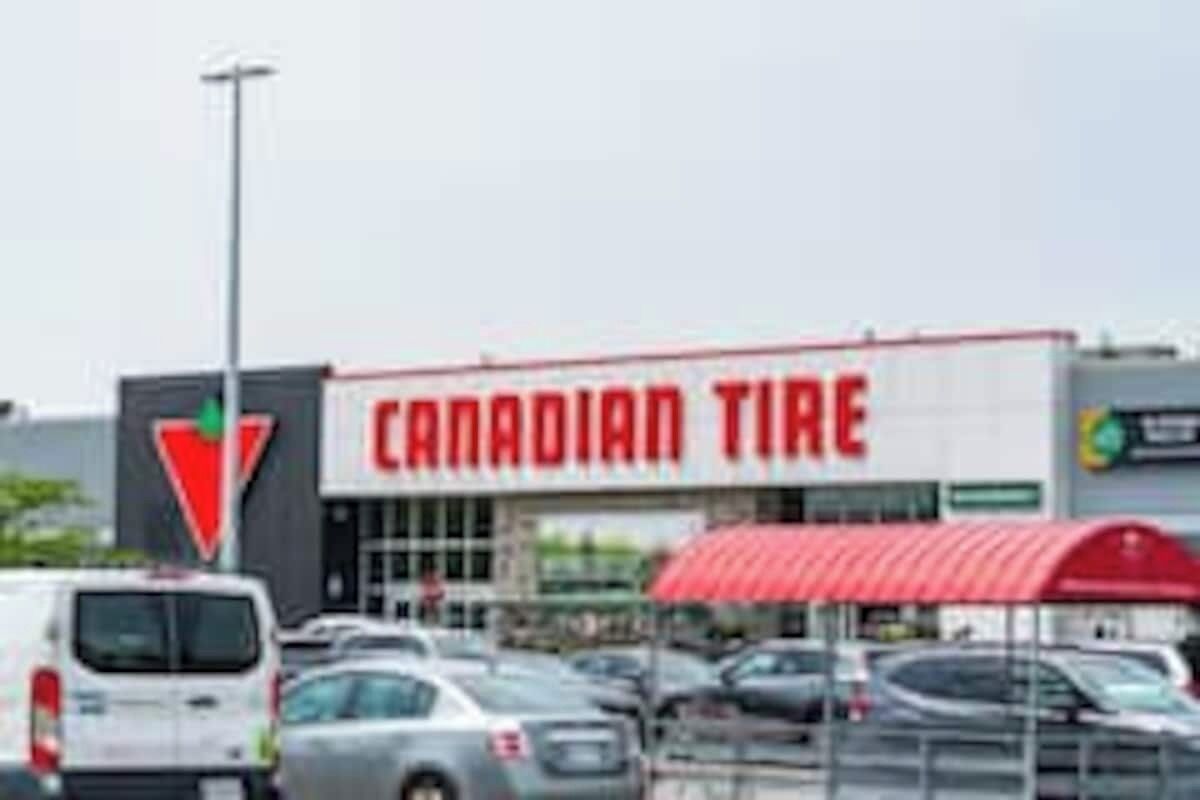 A Canadian Tire store with a red and white sign, a parking lot with several cars, and a red awning over the entrance.