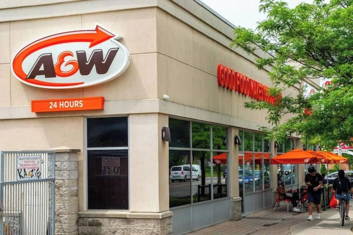 Ein Ladenlokal mit einem großen A&W-Logo, einem Schild für 24 Stunden und einem sichtbaren Eingang.
