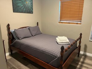 A single bed with a wooden frame and a grey quilted mattress. - 3-bedroom house in awesome Clearwater with everything Tampa Bay area can offer. (Clearwater)