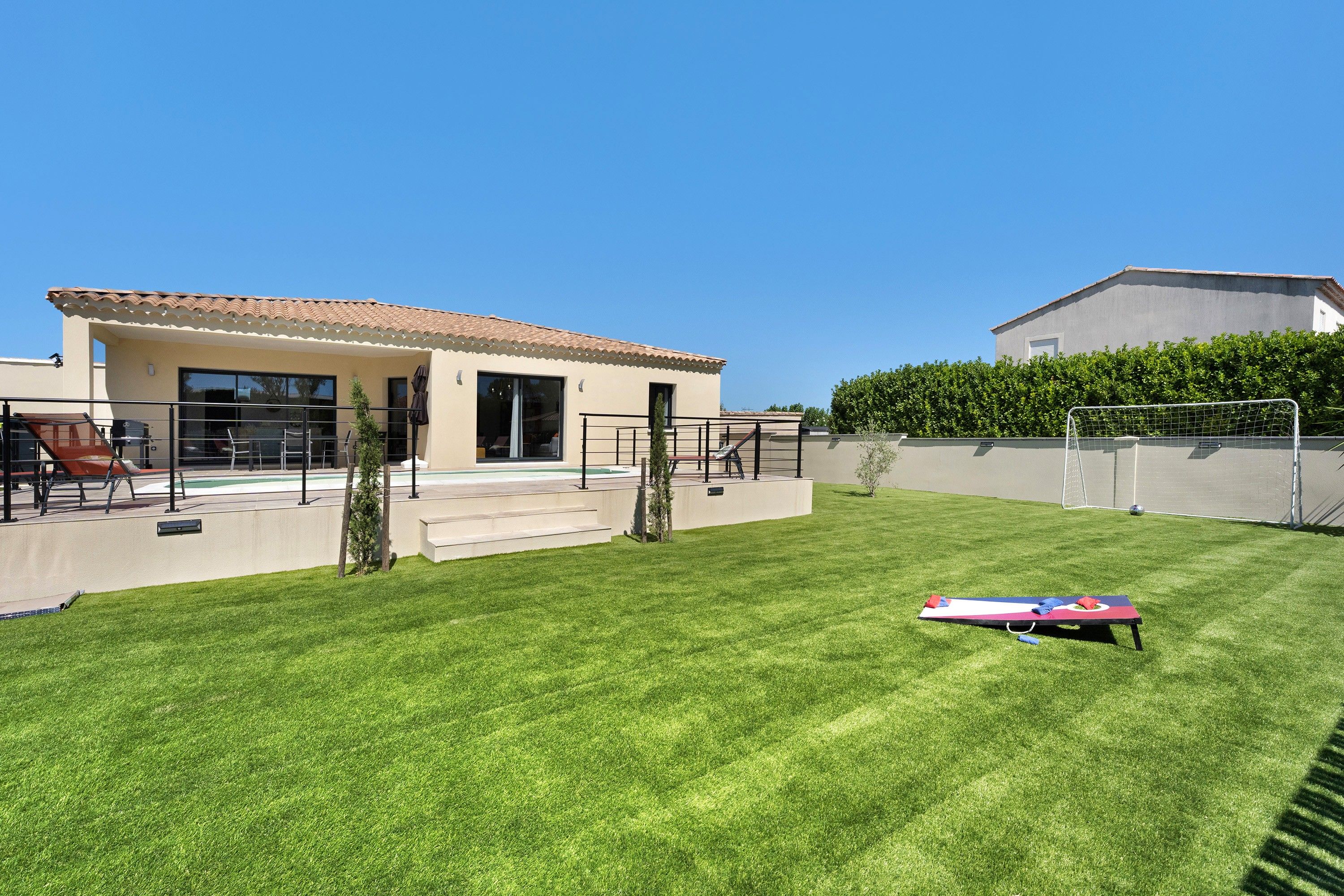 Il s'agit d'une propriété résidentielle dotée d'une pelouse bien entretenue, d'un patio aménagé avec du mobilier d'extérieur et d'une piscine.