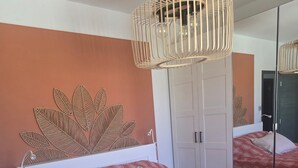 Una camera da letto con un letto, uno specchio e un lampadario a parete.
