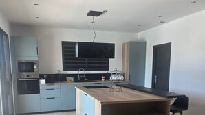 Una cucina moderna con elettrodomestici integrati, un'isola centrale e un'ampia finestra.
