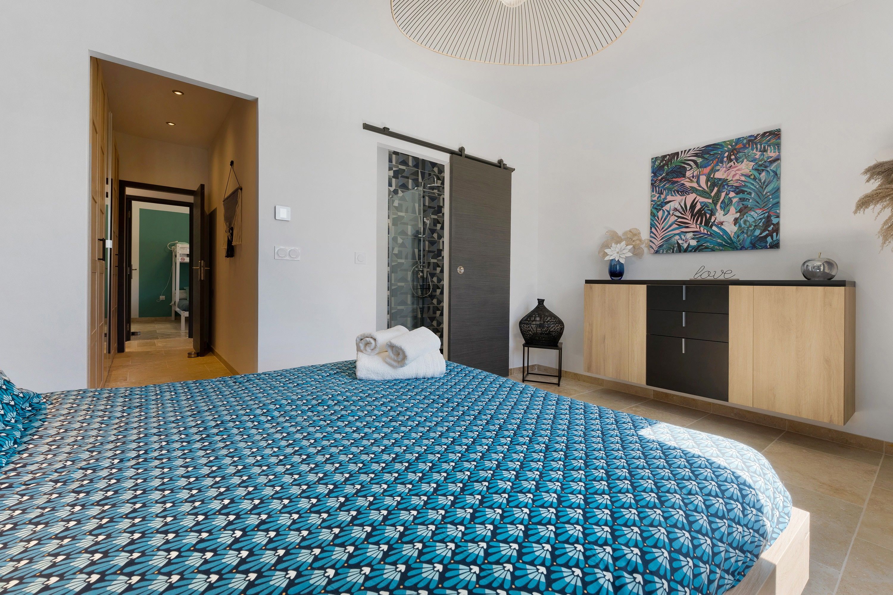 Une chambre à coucher avec un lit, une armoire, une douche et un tableau au mur.