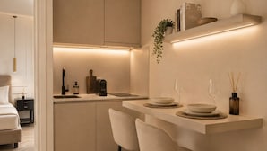 A modern kitchen with a central island, bar stools, and a dining area. - Five Suites 1 (Milan)