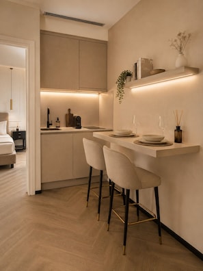 Una cocina moderna con una isla central, taburetes de bar y un comedor.