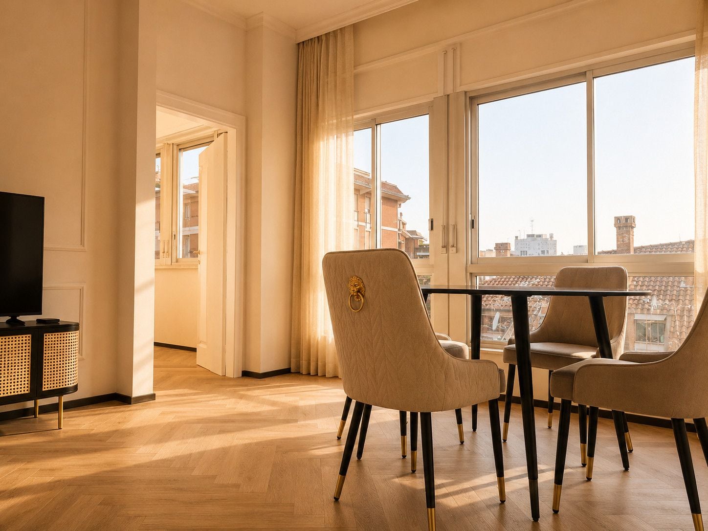 Una sala moderna con televisor, una mesa de comedor con sillas y ventanas grandes con vista a la ciudad.