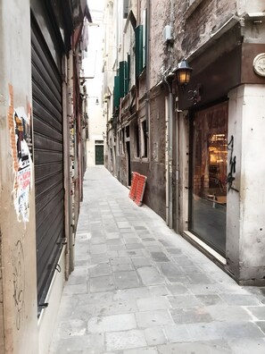 A narrow street with closed shops and a visible storefront with a sign. - Room 1 with Wi-Fi and Air Conditioning (Venezia)