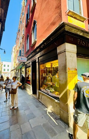 A street with a building featuring a storefront with a sign for a pizzeria. - Room 1 with Wi-Fi and Air Conditioning (Venezia)