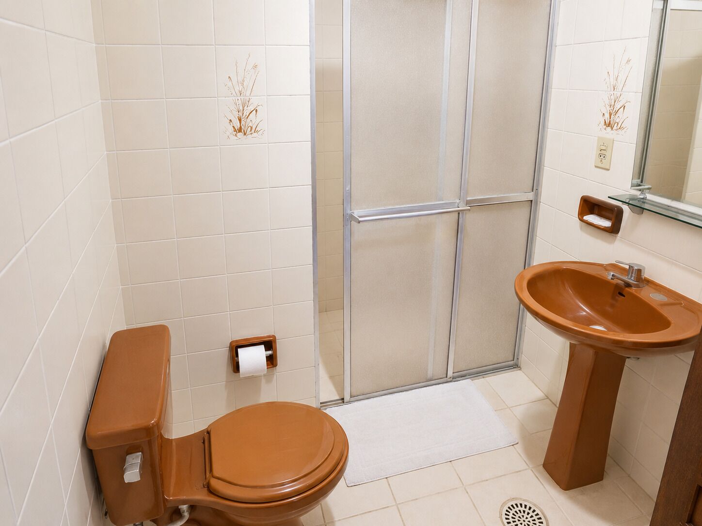 Un baño con inodoro, lavabo y zona de ducha.
