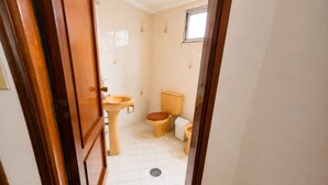 A bathroom with a toilet, sink, and window. - Gran Hotel Mediterráneo (Santa Cruz de la Sierra)