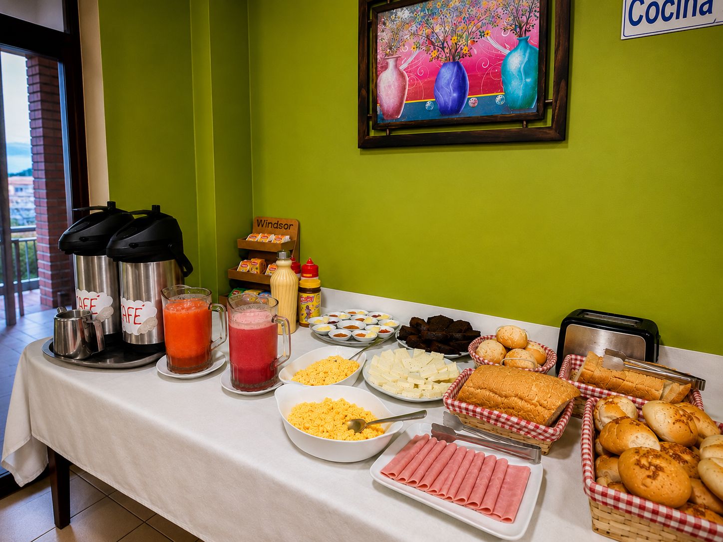 A breakfast buffet table with various food items, condiments, and a coffee station.