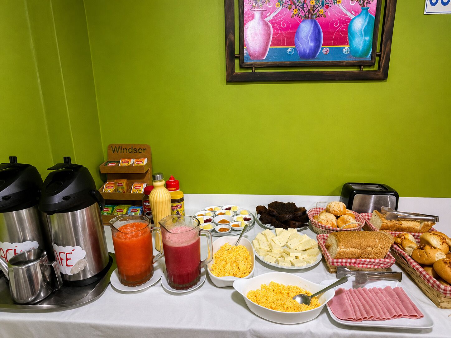 Buffet de café da manhã com diversos alimentos e bebidas.