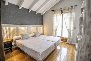 A bedroom with a large bed, a wooden headboard, and a window with curtains. - Vacation home with a private pool and garden, a barbecue, and close to beaches. (Arce)
