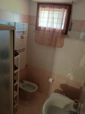 Une salle de bain équipée d’un bidet, de toilettes et d’un lavabo.