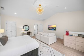 A hotel room with a bed, a sofa, a desk, a coffee machine, and a painting on the wall. - Luxurious Townhome in the Nations w/ Penthouse style top floor & walkout balcony (Nashville)