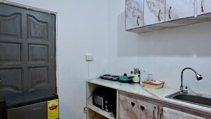Eine kleine Küche mit Kühlschrank, Mikrowelle und Spüle.