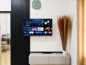 Ein Flachbildfernseher an der Wand zeigt eine Streaming-Dienstanwendung mit verschiedenen Inhaltsangeboten.