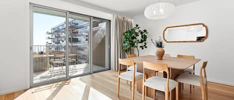 A modern interior with a dining area, a large window, and a view of a building.
