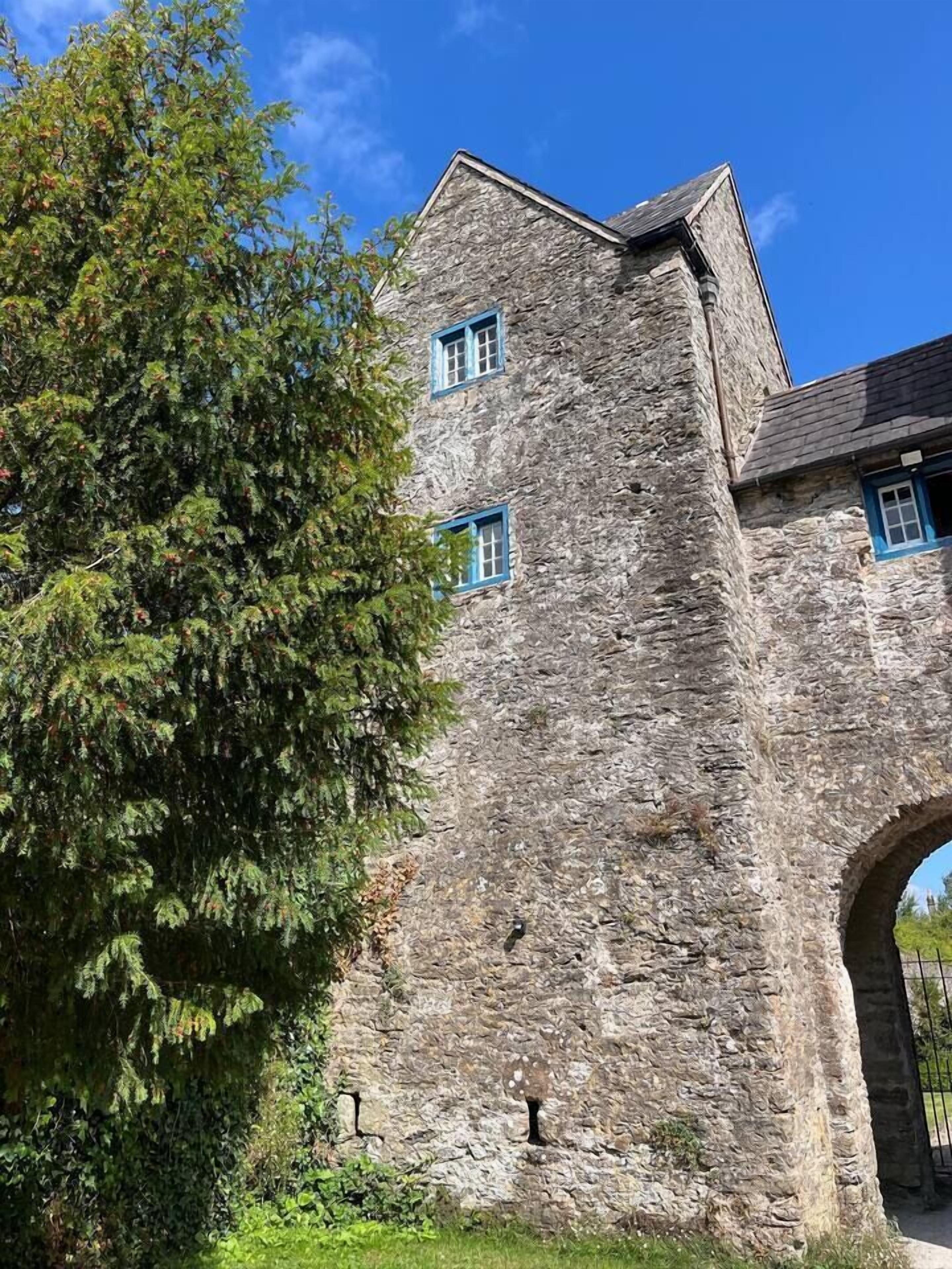 A stone building with a tower and arched entrance.
