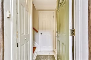 A hallway with a white door at the end, a green door to the right, and a wooden handrail on the left. - Dupont Circle Carriage House! With laundry/kitchen/AC (Washington)
