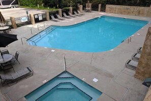 A rectangular swimming pool with a diving area, surrounded by lounge chairs and tables. - Mountain View Retreat 🏔️ Private Hot Tub, Arcade Room, Steps to Pigeon Forge Fun (Pigeon Forge)