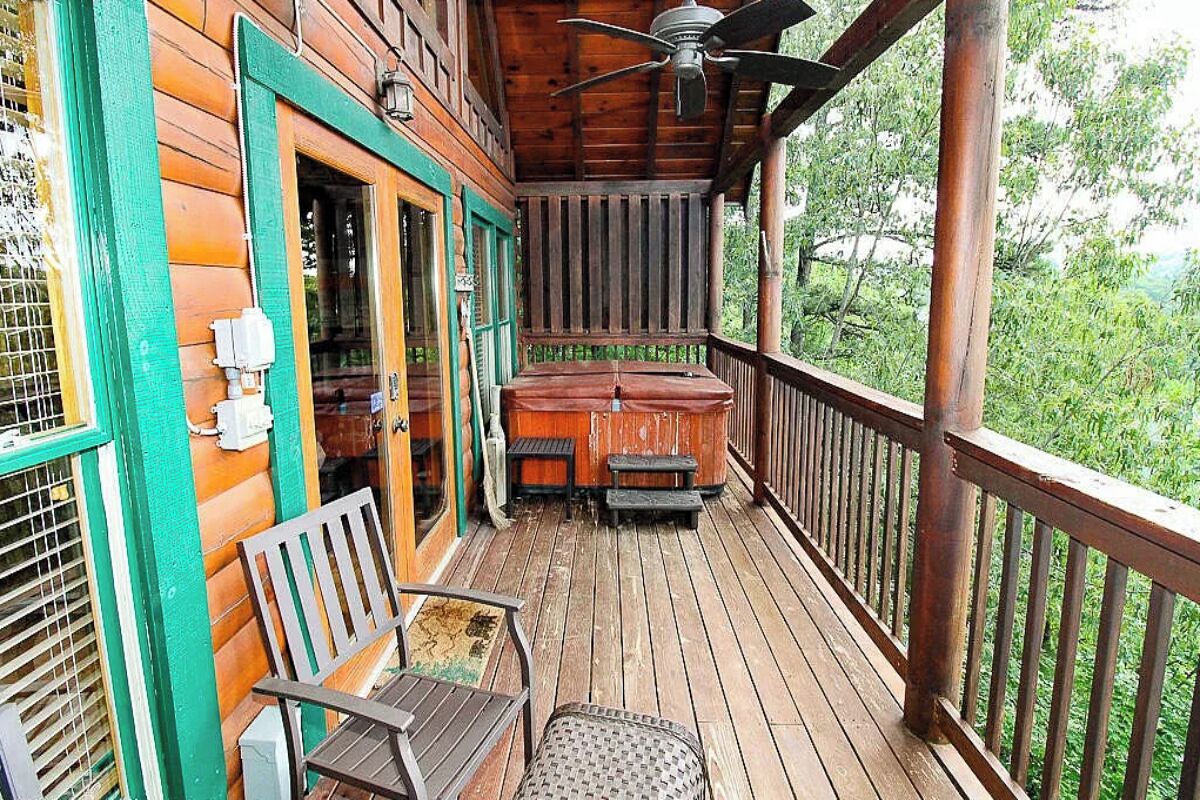 A wooden deck with a covered seating area and a ceiling fan.