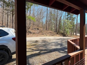 A covered outdoor area with a gravel path leading to a forested area.