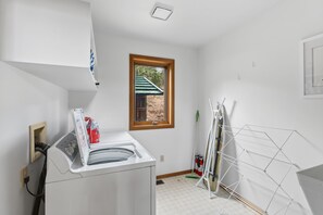 A laundry room with a washing machine, a window, and a drying rack. - First Light Cabin Breck - Deck & Views (Breckenridge)