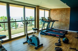 A gym with exercise equipment, large windows, and a view of the ocean. - Studio beira-mar nas piscinas naturais Tamandaré (Tamandaré)