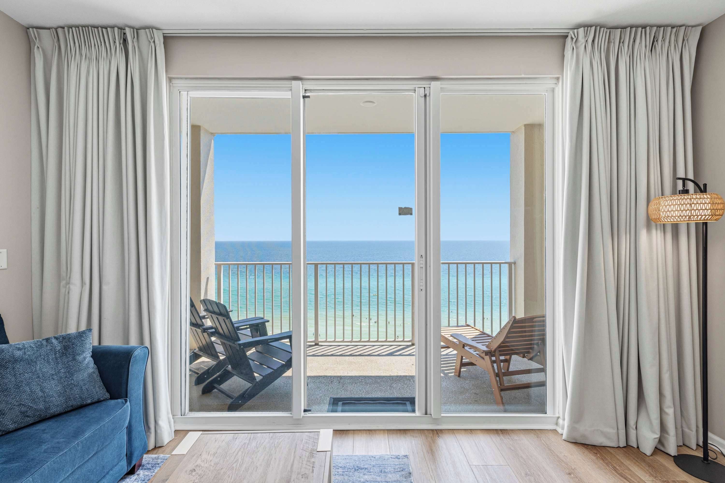 Une pièce avec vue sur la mer, un canapé et une table avec des chaises.