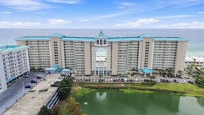 Ein großes Hotel mit mehreren Etagen, einem Innenhof und Blick aufs Meer.
