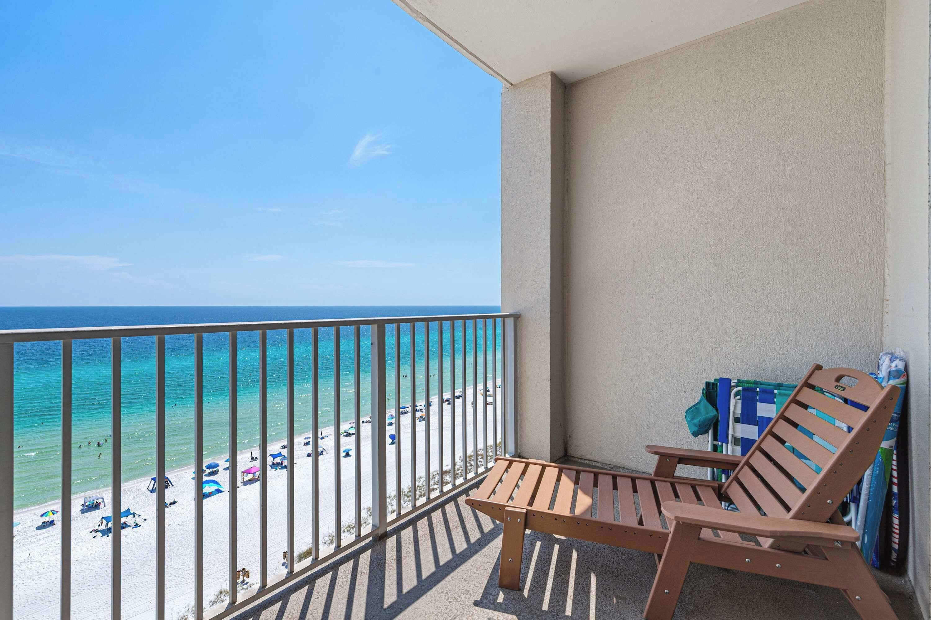 A balcony with a view of a beach and ocean.