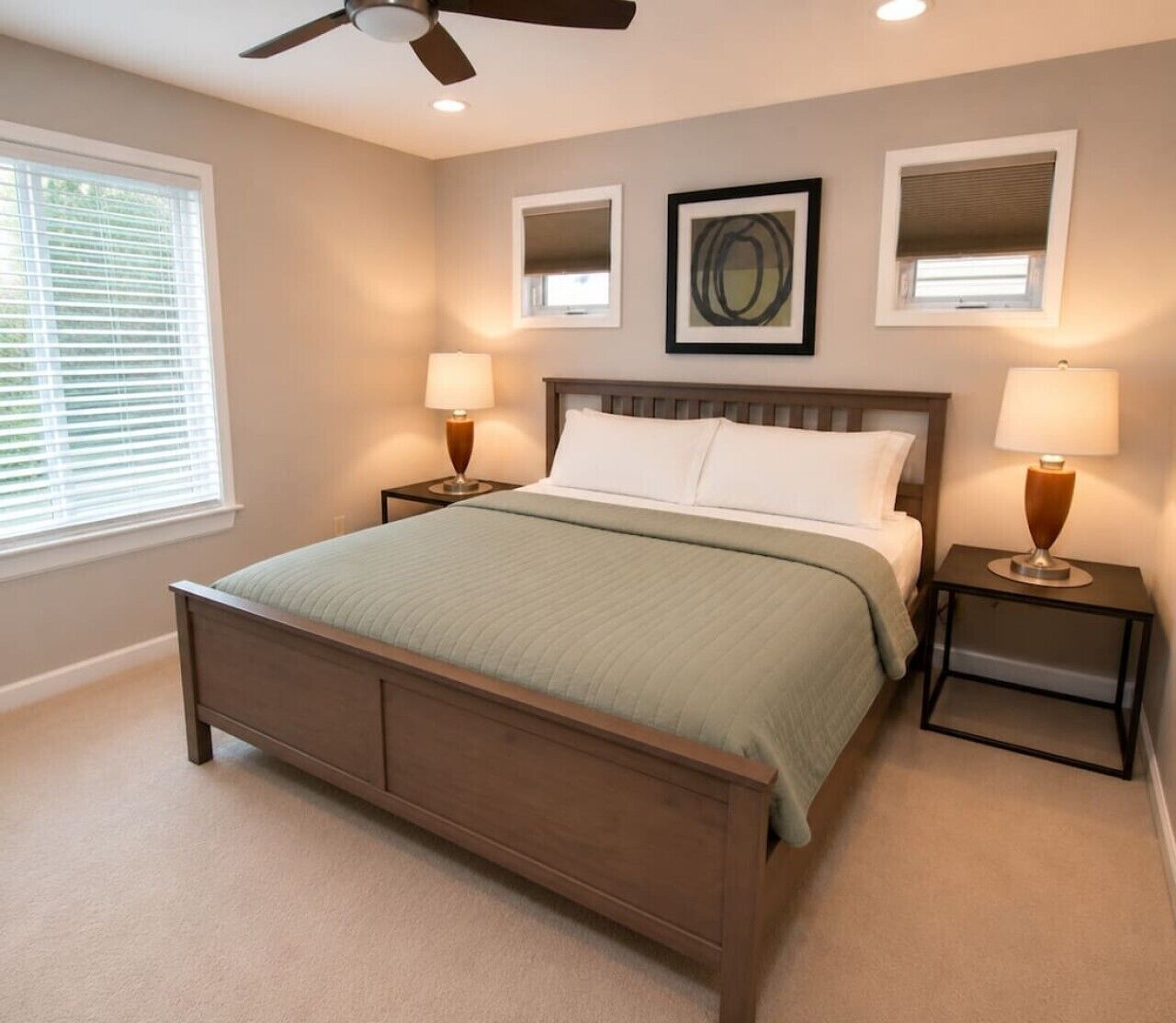A bedroom with a bed, two bedside tables, a ceiling fan, and a window with blinds.