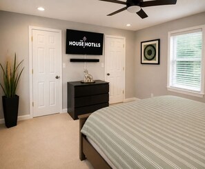 A bedroom with a bed, a ceiling fan, a TV, and a dresser. - Near downtown, Tremont, Ohio City, Rock Hall (Cleveland)