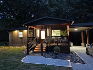 A modern house with a covered porch, a staircase, and a car parked in the driveway. - Nightingale Nest - Boutique Retreat + Hot Tub (Stockbridge)