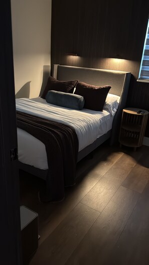 A bedroom with a bed, bedside table, and a lamp. - Nightingale Nest - Boutique Retreat + Hot Tub (Stockbridge)