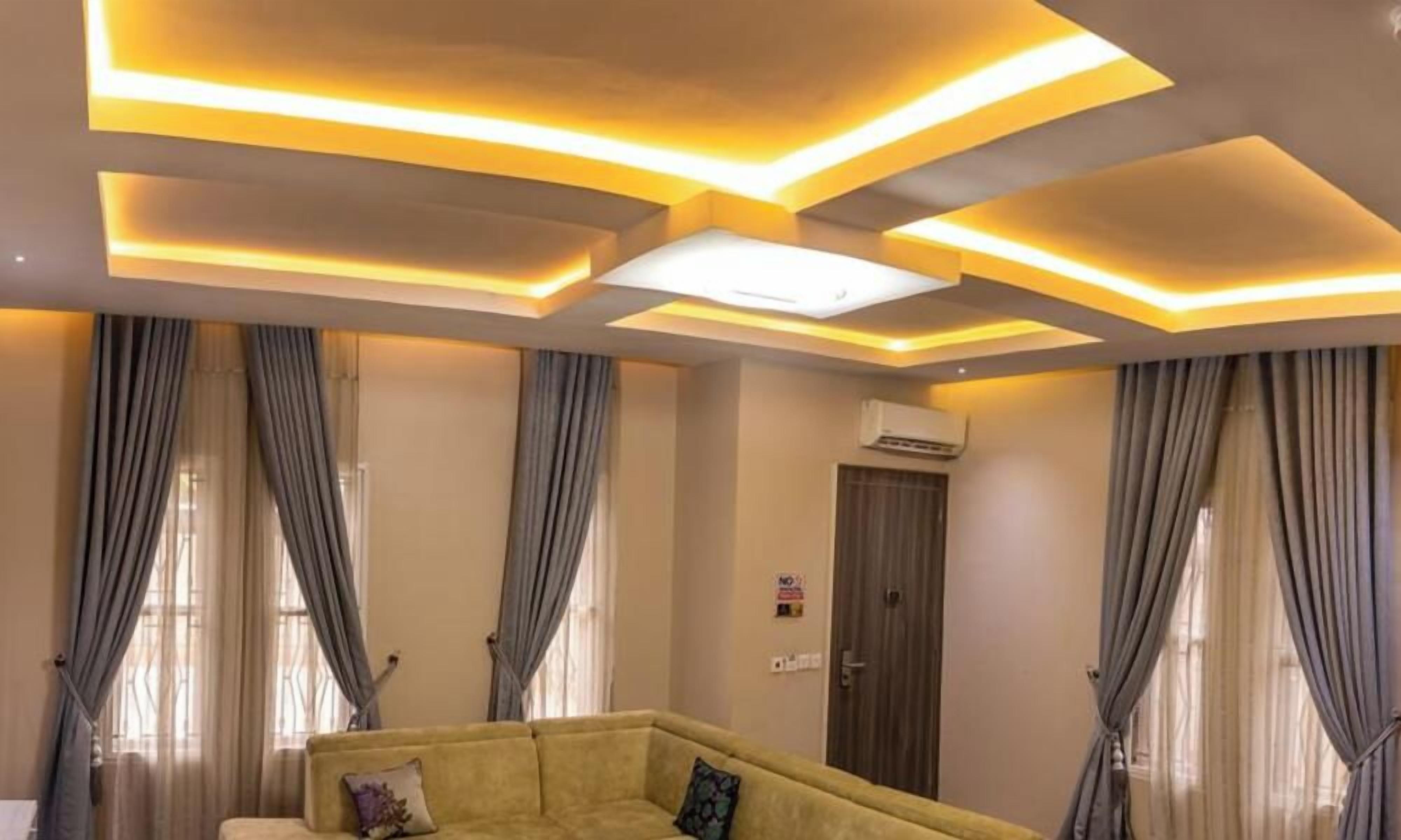 Habitación con sofá, cortinas e iluminación empotrada en el techo.