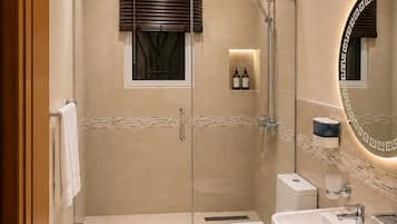 A modern bathroom with a glass-enclosed shower, a toilet, and a sink.